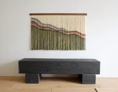 a black bench sitting on top of a wooden floor next to a wall mounted painting