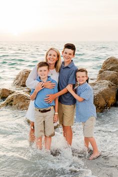 a family standing in the ocean with their arms around each other