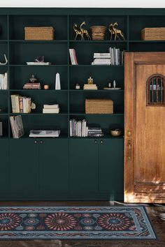 a room with green bookshelves and baskets on top of the bookcases