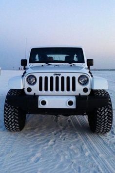 a white jeep is parked in the snow