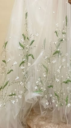 there is a white curtain with flowers on it