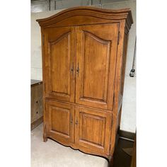 an old wooden armoire sitting on top of a white floor next to a wall