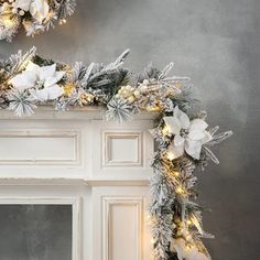 a fireplace decorated for christmas with silver and white decorations