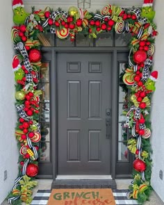 the front door is decorated for christmas with candy canes and wreaths on it