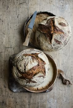 two loaves of bread sitting on top of a wooden table