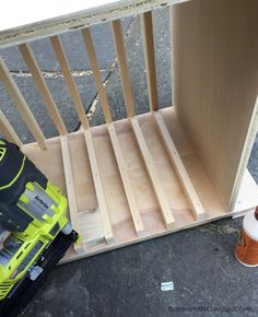 a cordless driller sitting on top of a wooden shelf next to some construction supplies