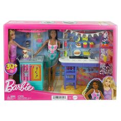 the barbie doll plays with her kitchen set