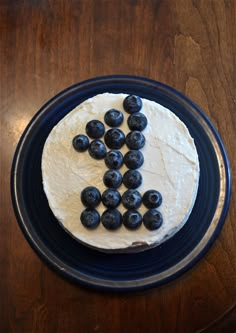 a cake with blueberries on it sitting on top of a table