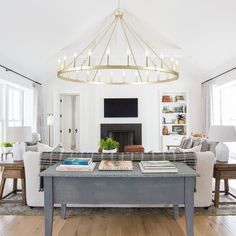 a living room filled with furniture and a large chandelier over the fire place