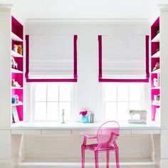 a pink chair sitting in front of a window next to a desk with a computer on it