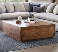 a living room filled with furniture and a wooden coffee table in front of a window