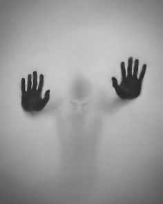 two hands in front of a person's face with the shadow of their hands