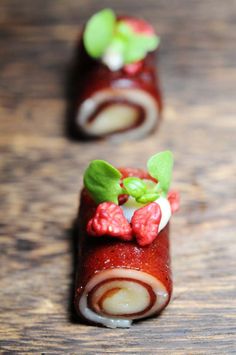 some food is laying out on a wooden table and it looks like they are rolled up