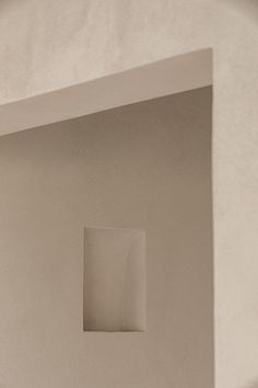 a white toilet sitting in a bathroom next to a wall with a square hole on it