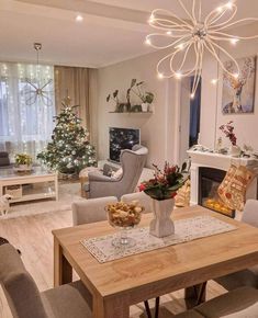 a living room filled with furniture and a christmas tree in the corner near a fire place