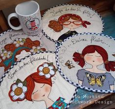 four embroidered coasters with pictures of women on them and coffee mug in the background