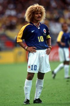 the soccer player is standing on the field with his hands on his hips as he looks down