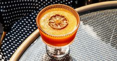 an orange drink sitting on top of a glass table