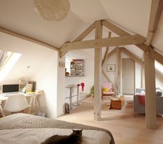 an attic bedroom with white walls and wood beams