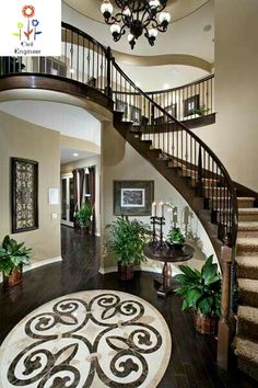 a staircase in a house with potted plants on the floor and chandelier