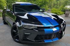 a blue and black chevrolet camaro parked in a parking lot