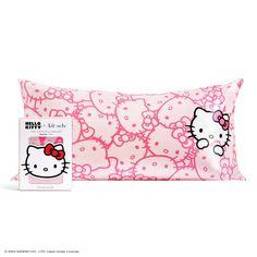 a pink pillow with hello kitty on it next to a package for the pillow case