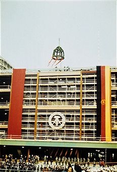 a large building under construction with scaffolding on the side and people walking around