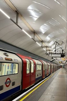 a red and white train is pulling into the station