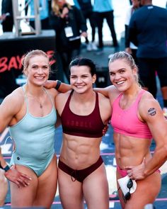 three women standing next to each other in bikinis and one has her arm around another woman's shoulder