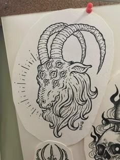 some stickers are hanging on the wall next to a paper with an image of a ram