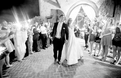 a bride and groom walking down the aisle with sparklers in their hands as they exit