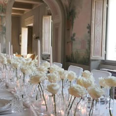 a long table with white flowers and candles on it