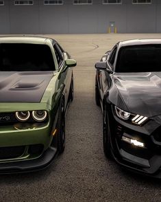 two green and black cars parked next to each other