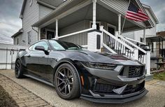 the chevrolet camaro is parked in front of a house