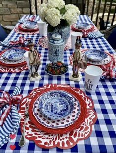 a blue and white table cloth with red, white and blue plates sitting on top of it