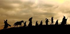 silhouettes of people and horses on a hill