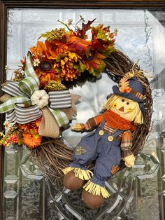 a fall wreath with a scarecrow and pumpkins