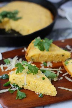 an omelet is on a wooden plate with parmesan cheese and cilantro