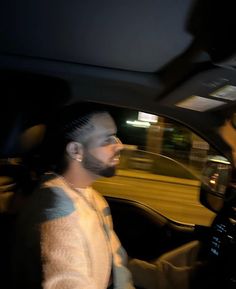 a man sitting in the driver's seat of a car with his head up