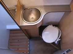 an overhead view of a bathroom with a sink, toilet and stairs to the second floor