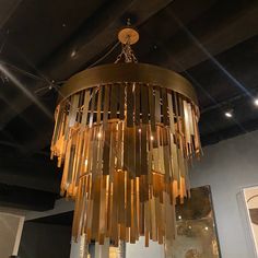 a gold chandelier hanging from the ceiling in a room with mirrors and lights