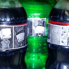 two green and black soda bottles sitting next to each other