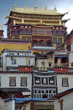 an old building with many windows and decorations on the top, next to other buildings