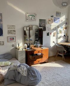 a bedroom with a bed, desk and dresser in it's corner area next to a window