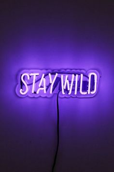 a purple neon sign that says stay wild on it's side in the dark