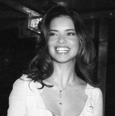 a black and white photo of a woman smiling