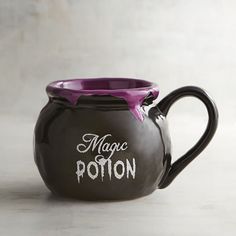 a black and purple ceramic pot with the word magic potter painted on it's side