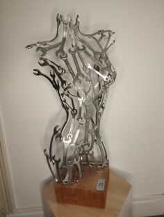 a metal sculpture on top of a wooden table