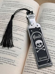 a bookmark with a skull and crossbones on it sitting on top of an open book