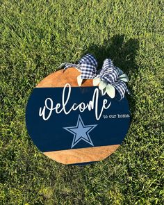 a wooden sign that says welcome to our home with a blue star and plaid bow